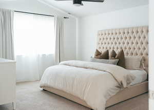 Carpeted bedroom with a ceiling fan