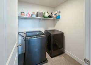 Laundry room with washing machine and clothes dryer and baseboards