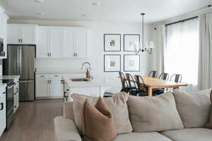 Living room featuring hanging lights and dark wood finished floors