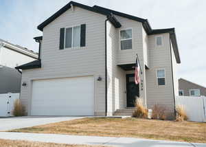 Traditional home featuring a gate, a garage, and driveway