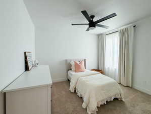 Bedroom featuring a ceiling fan and light carpet