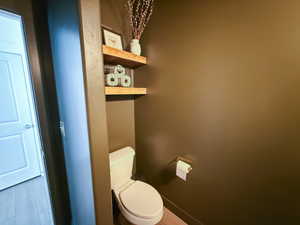 Bathroom featuring toilet and light wood finished floors