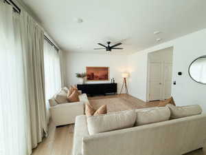 Living area with light wood finished floors and ceiling fan