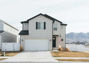 View of front of house featuring a gate, a mountain view, driveway, and an attached garage