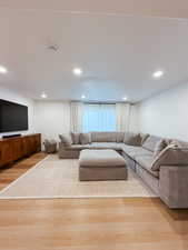 Living room with light wood-style flooring and recessed lighting