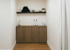 Bar area with light wood finished floors and open shelves