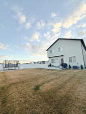 Rear view of property featuring a patio and a trampoline
