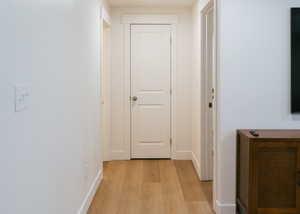 Hallway featuring light wood-type flooring and baseboards