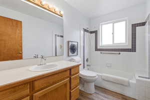 Bathroom featuring vanity, bathtub / shower combination, and dark wood-style floors
