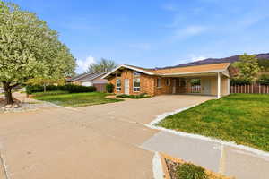 Single story home with a carport, concrete driveway, and brick siding