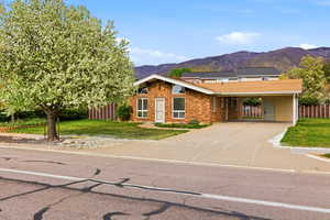 View of front of home with driveway, a mountain view, and brick siding