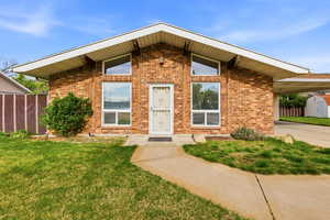 View of front of property featuring brick siding and a carport