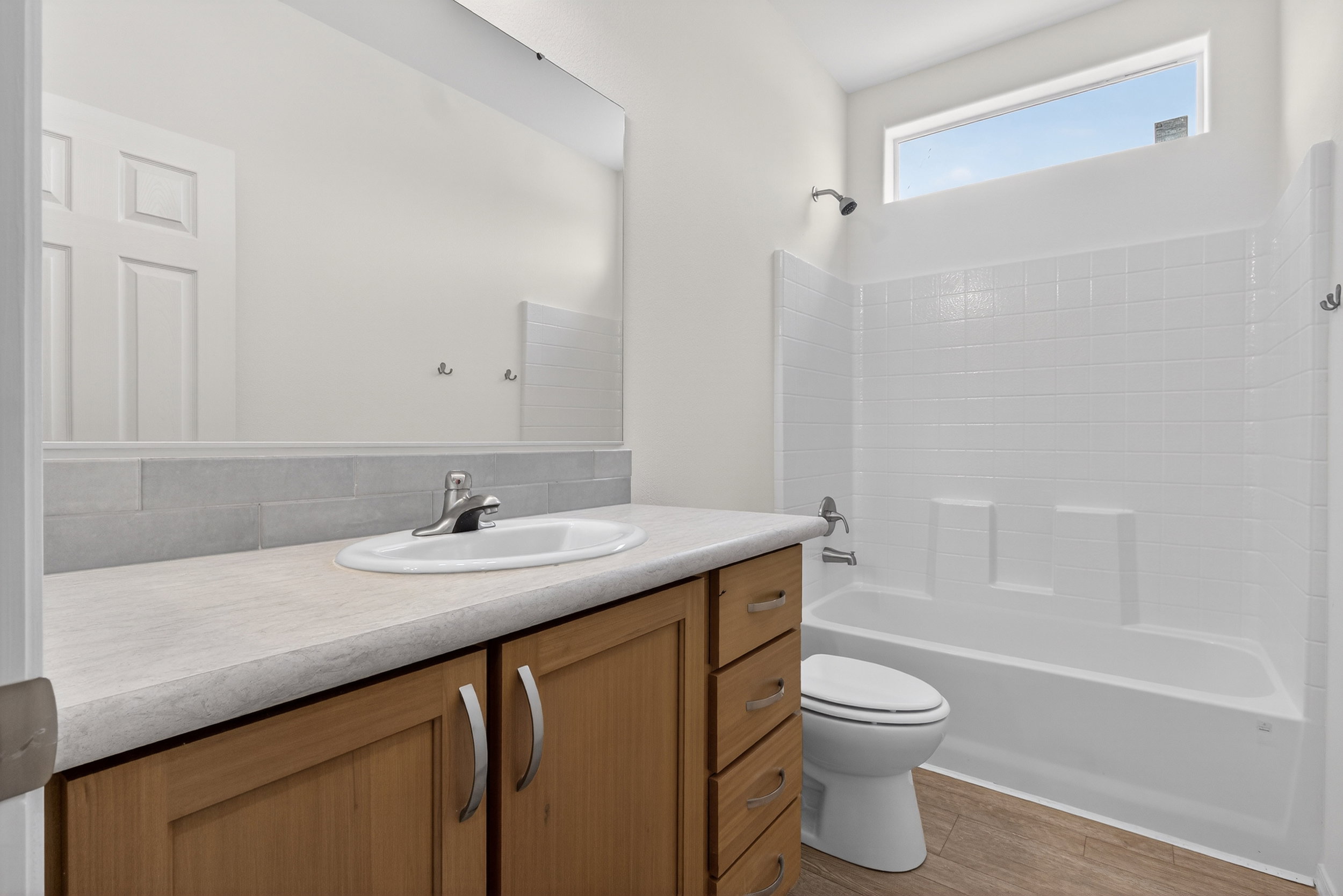 Bathroom with vanity, bathtub / shower combination, and light wood-style floors