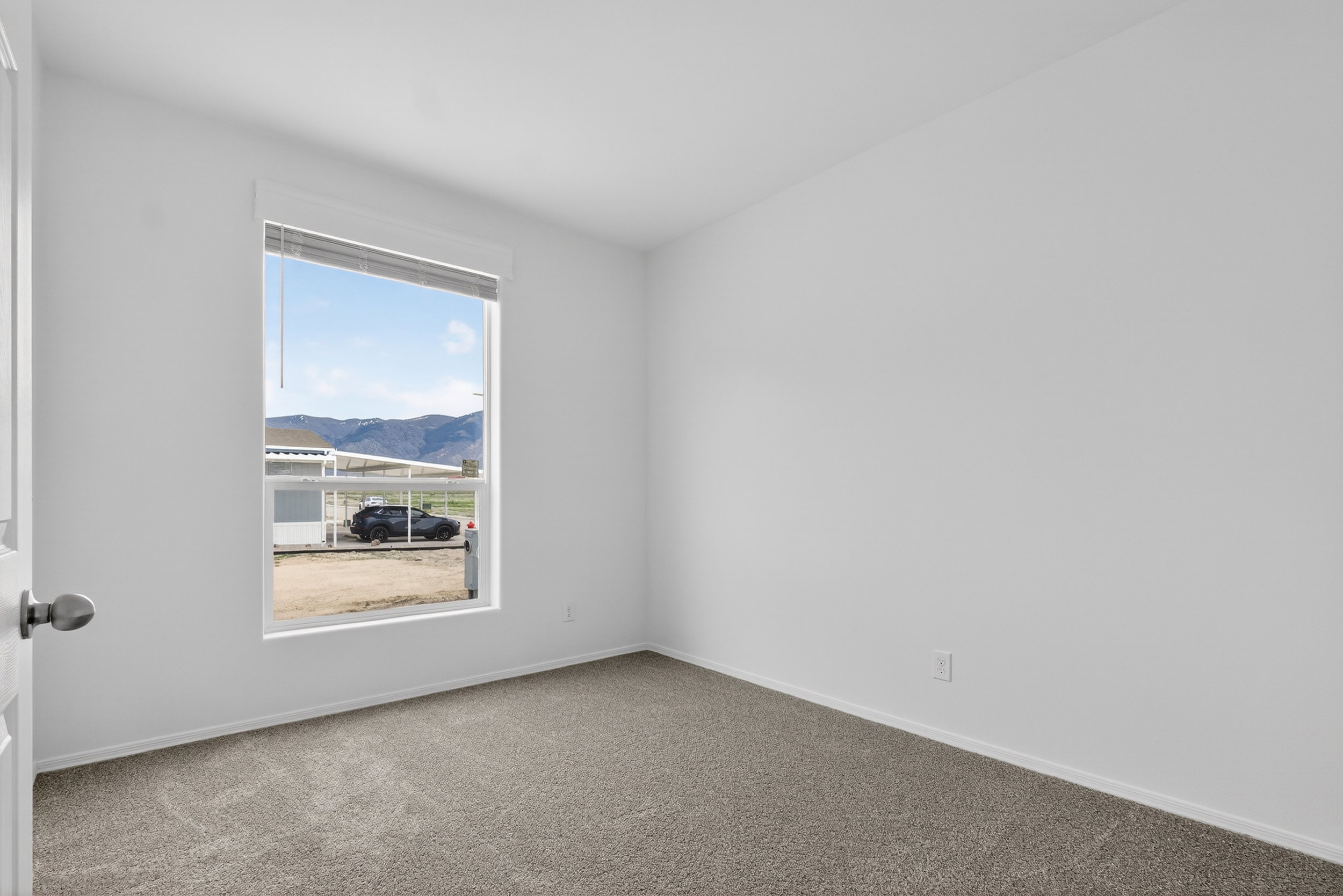 Empty room with carpet flooring and a mountain view