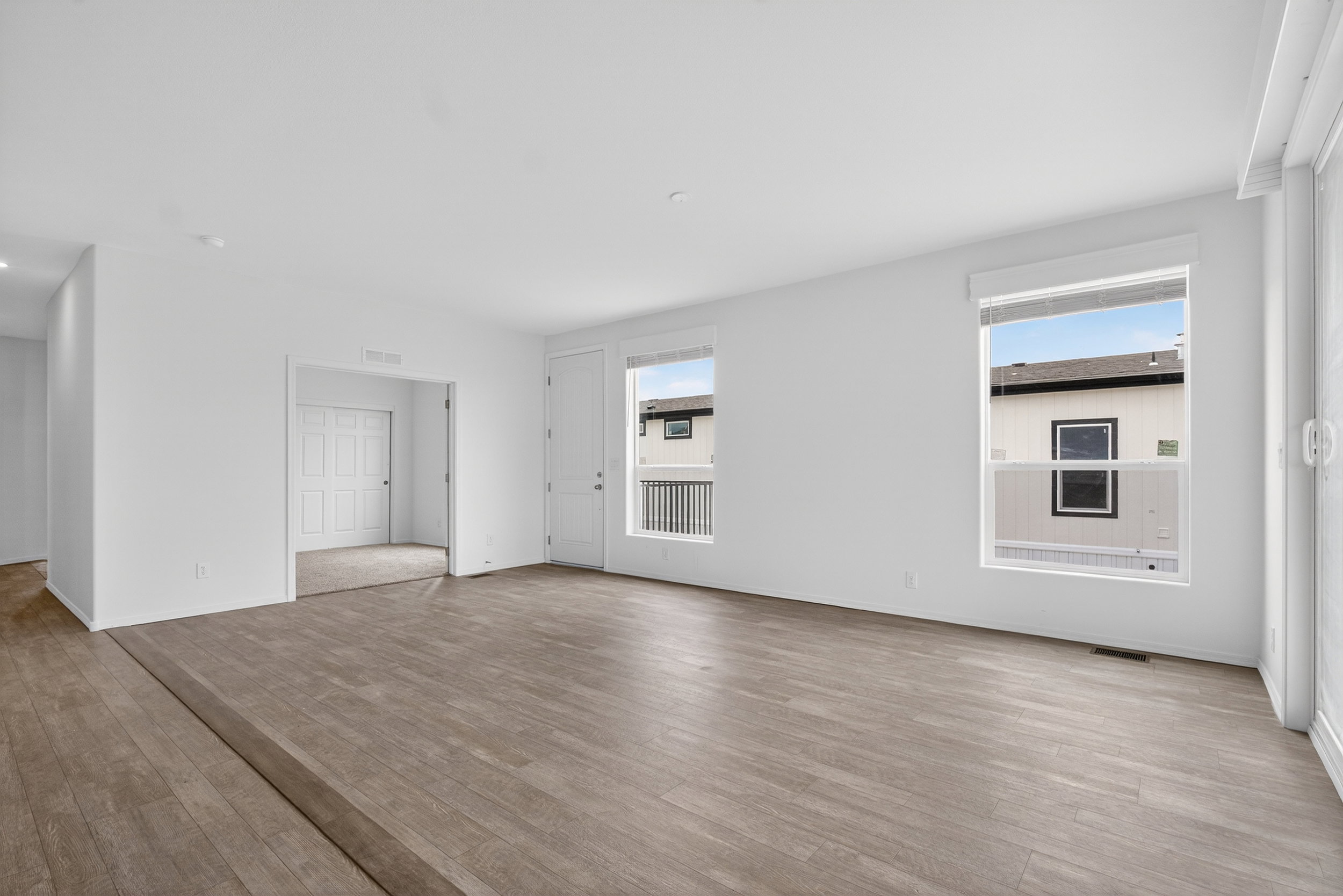 Unfurnished living room with wood finished floors and baseboards