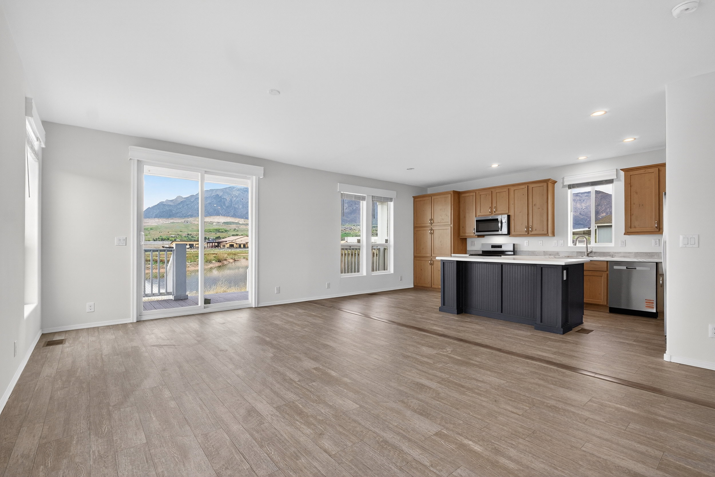 Kitchen featuring a mountain view, open floor plan, light countertops, stainless steel appliances, and light wood-style flooring