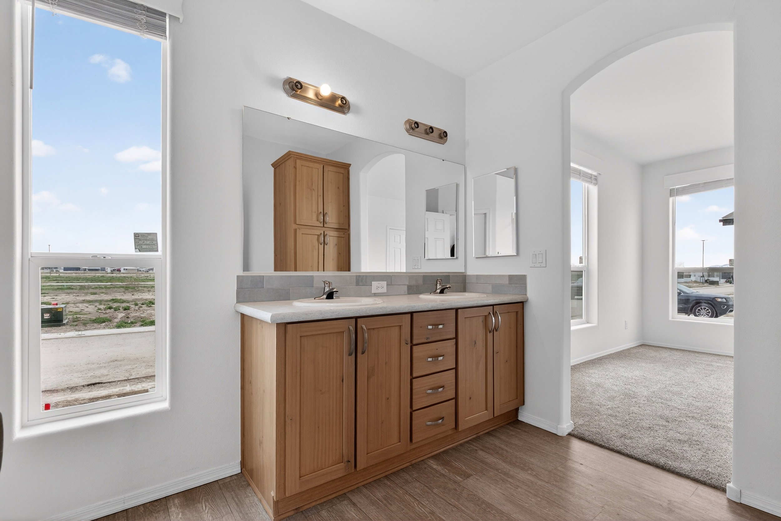 Full bathroom featuring double vanity and light wood-style flooring