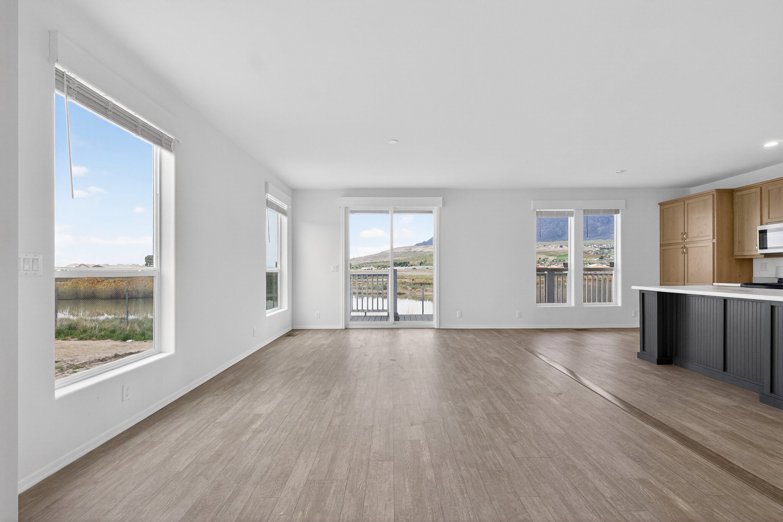 Unfurnished living room with light wood-type flooring and baseboards