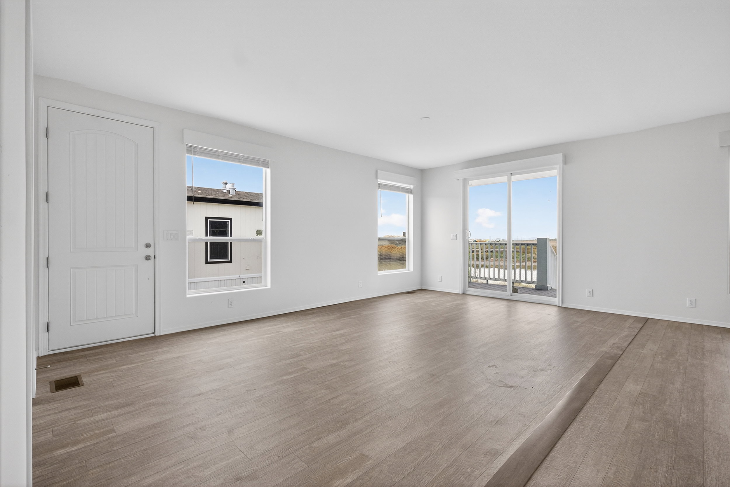 Unfurnished living room featuring dark wood-style floors and baseboards