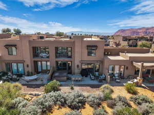 Back of property featuring outdoor furniture, stucco siding, a patio area, and a mountain view