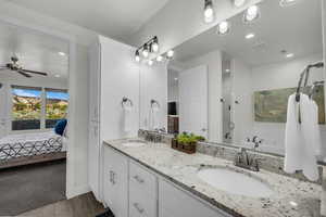 Ensuite bathroom with double vanity, a stall shower, a garden tub, ceiling fan, and dark wood finished floors