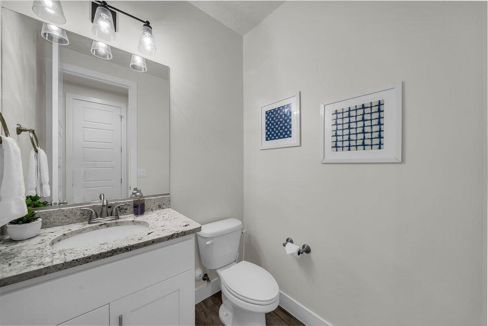 Half bath featuring vanity and dark wood-type flooring