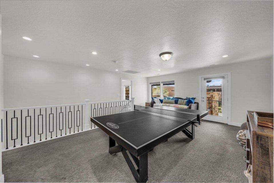 Playroom featuring dark carpet, a textured ceiling, and recessed lighting