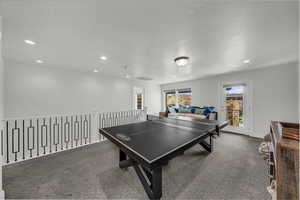 Playroom featuring dark carpet, a textured ceiling, and recessed lighting