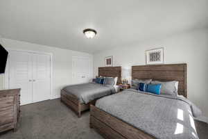 Bedroom featuring dark carpet and two closets