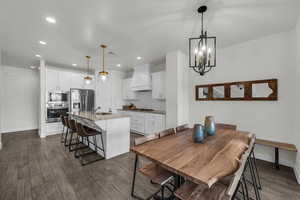 Dining area featuring dark wood finished floors and suspended lighting