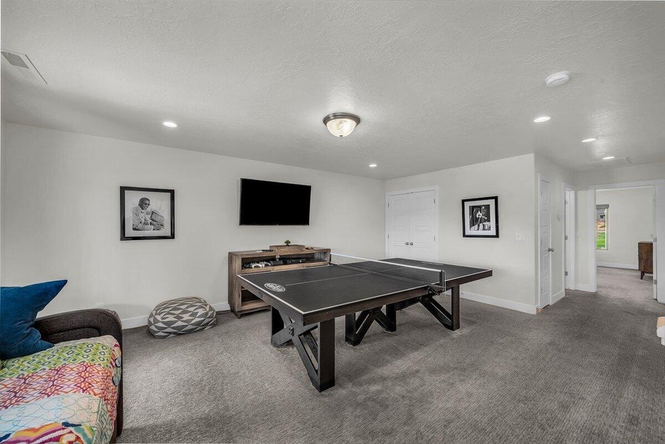 Rec room with carpet flooring, a textured ceiling, and recessed lighting