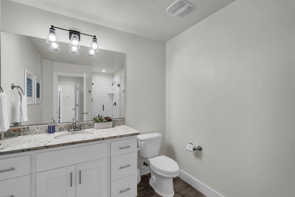 Bathroom featuring vanity, a stall shower, and dark wood-type flooring