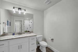 Bathroom featuring vanity, a stall shower, and dark wood-type flooring