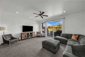 Carpeted living area featuring a textured ceiling, ceiling fan, and recessed lighting