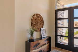 Entryway with french doors, healthy amount of natural light, and wood finished floors