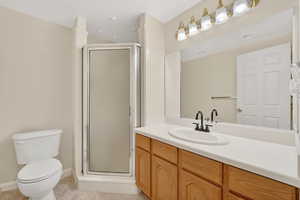 Full bathroom featuring a shower stall, vanity, and light tile patterned flooring