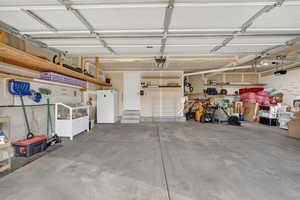 Garage with freestanding refrigerator and a garage door opener