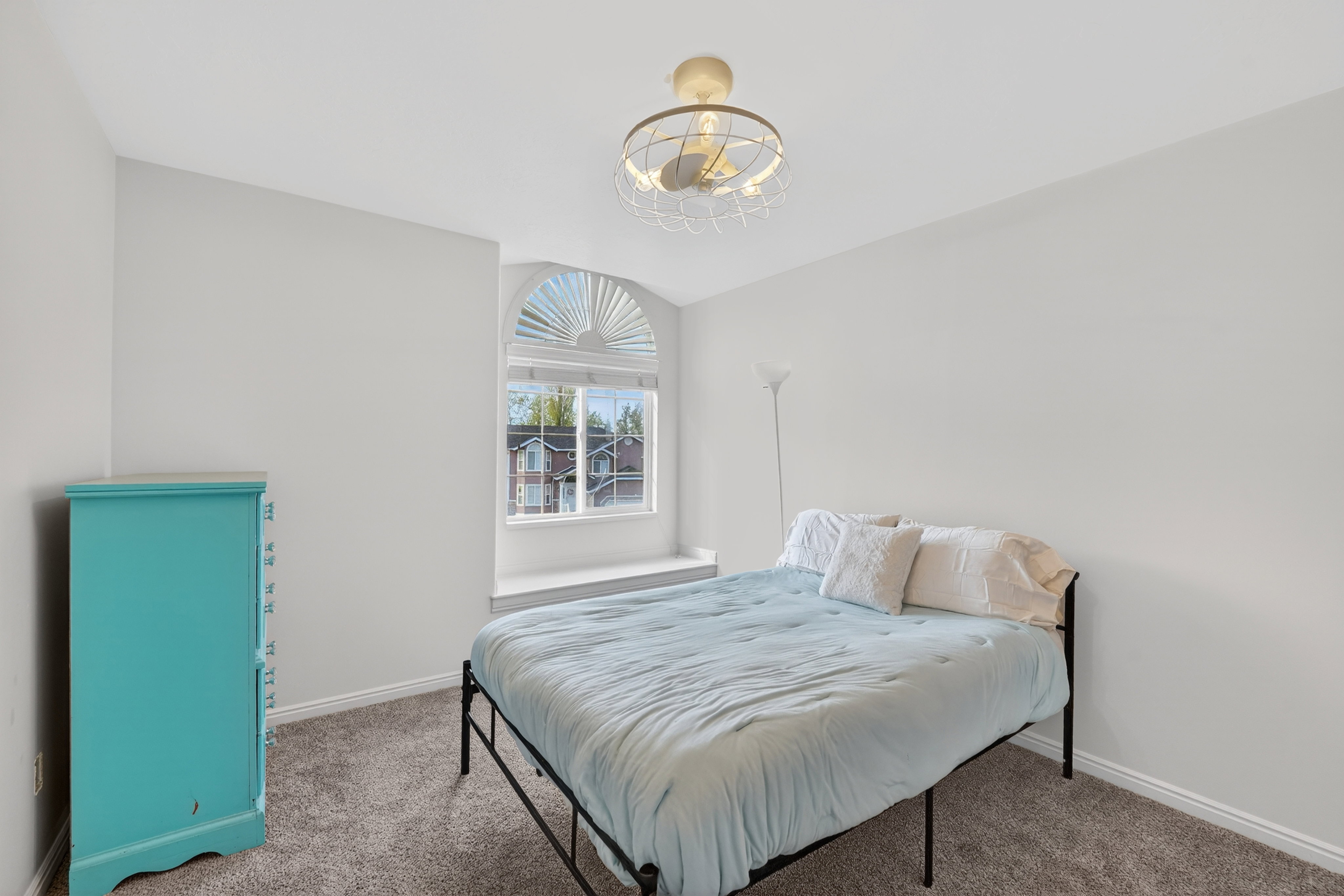 Carpeted bedroom with a chandelier and baseboards