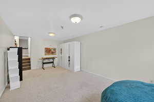 Bedroom featuring light carpet and baseboards