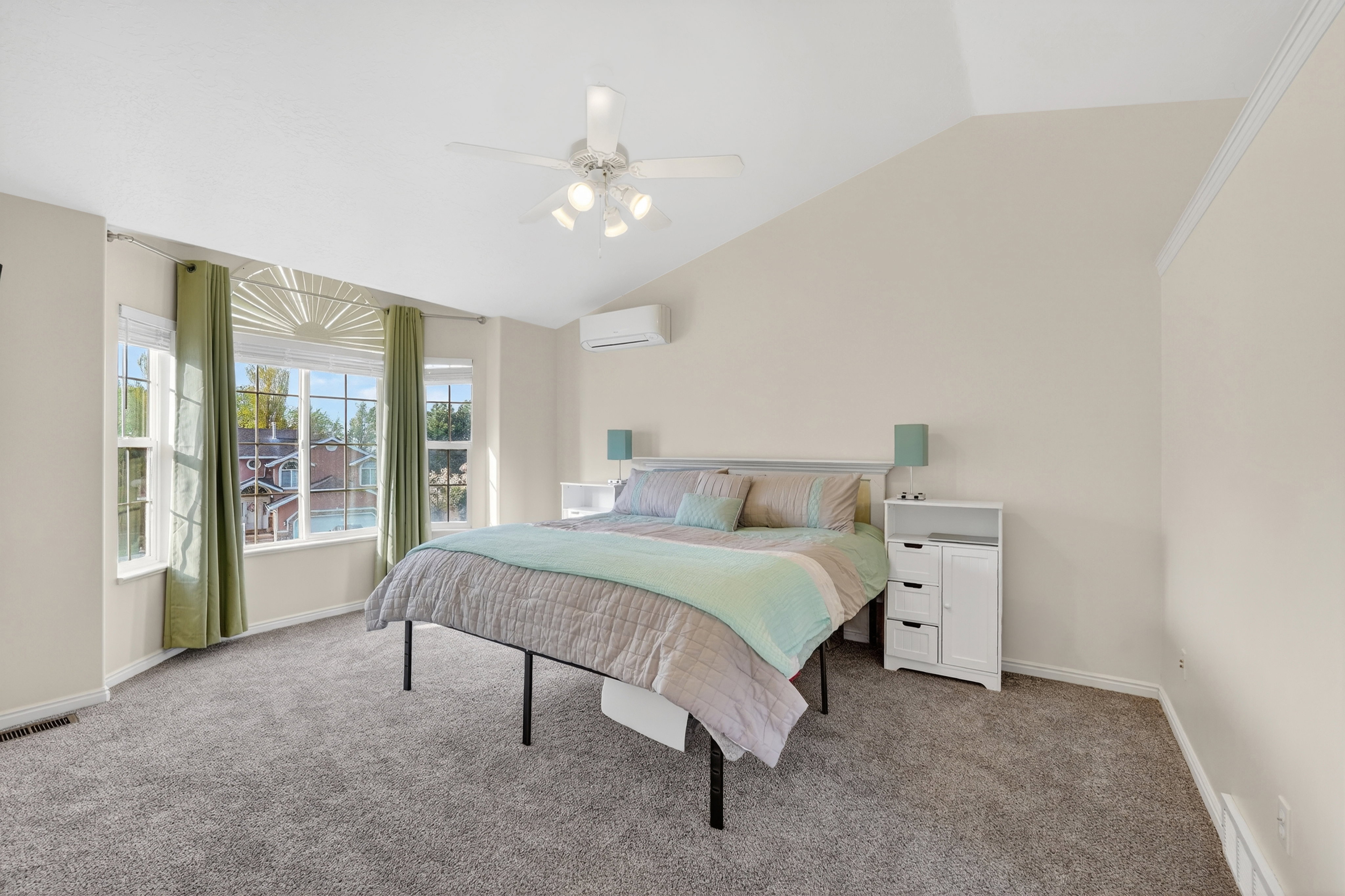 Bedroom featuring light colored carpet, lofted ceiling, and a ceiling fan