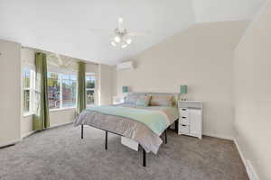Bedroom featuring light colored carpet, lofted ceiling, and a ceiling fan