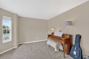 Living area with light carpet and baseboards