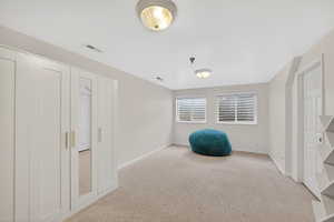 Unfurnished room featuring light carpet and baseboards