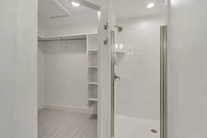 Full bath with light carpet, a stall shower, recessed lighting, and a spacious closet