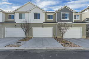 View of front of home featuring stucco siding, an attached garage, and driveway