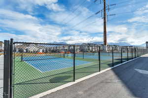 View of tennis court with a mountain view and a residential view