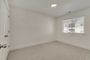 Empty room featuring light colored carpet and baseboards