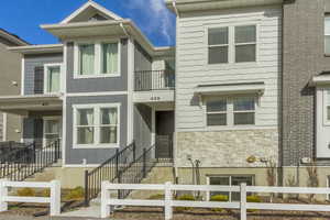 View of front of house featuring board and batten siding, a balcony, and stone siding