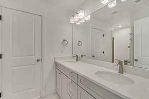 Full bath featuring double vanity and baseboards