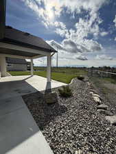 Fenced backyard featuring a patio and a view of countryside